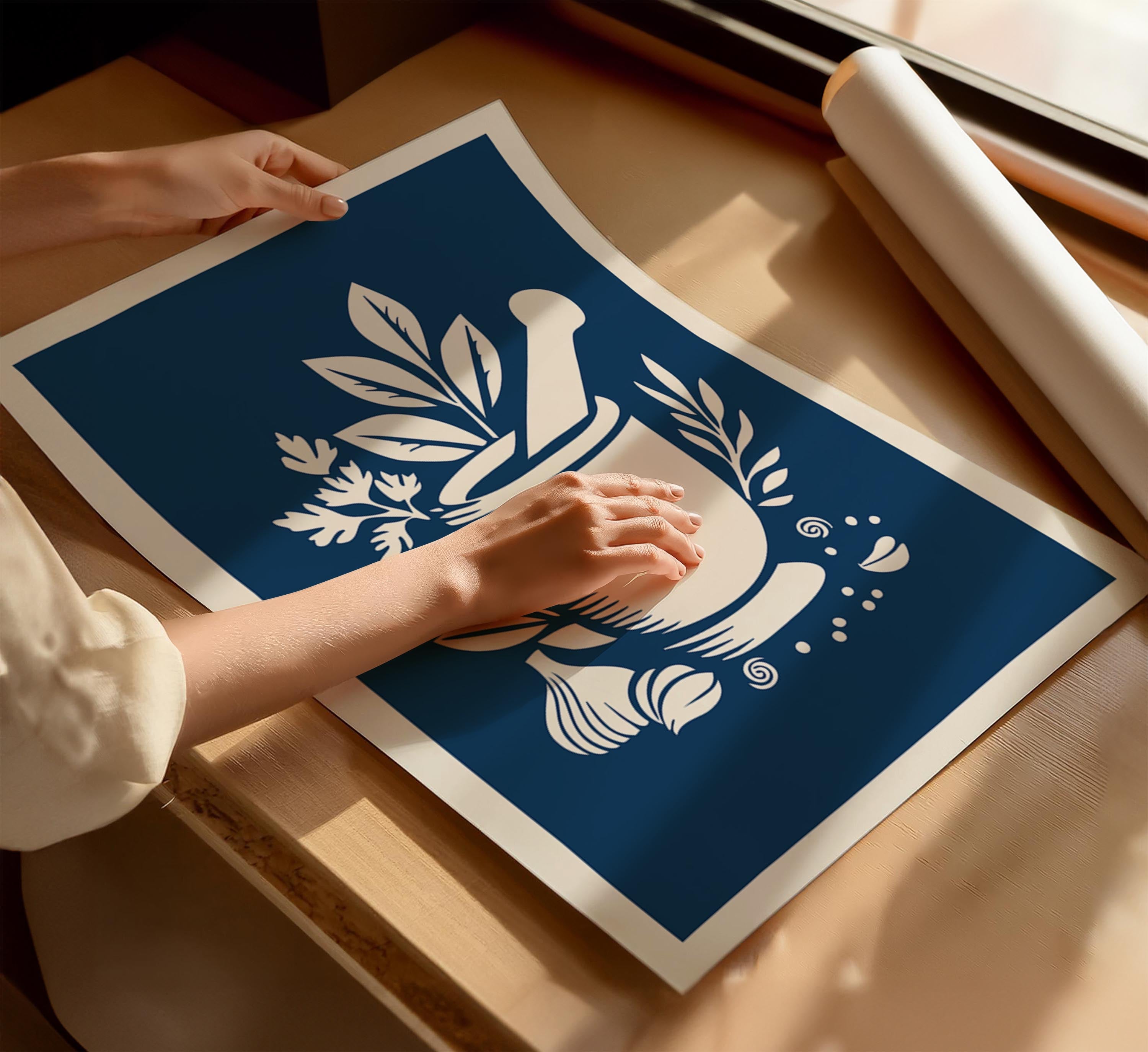 A person's hands are holding a blue and white poster with a stylized design featuring a mortar and pestle, leaves, and other decorative elements.