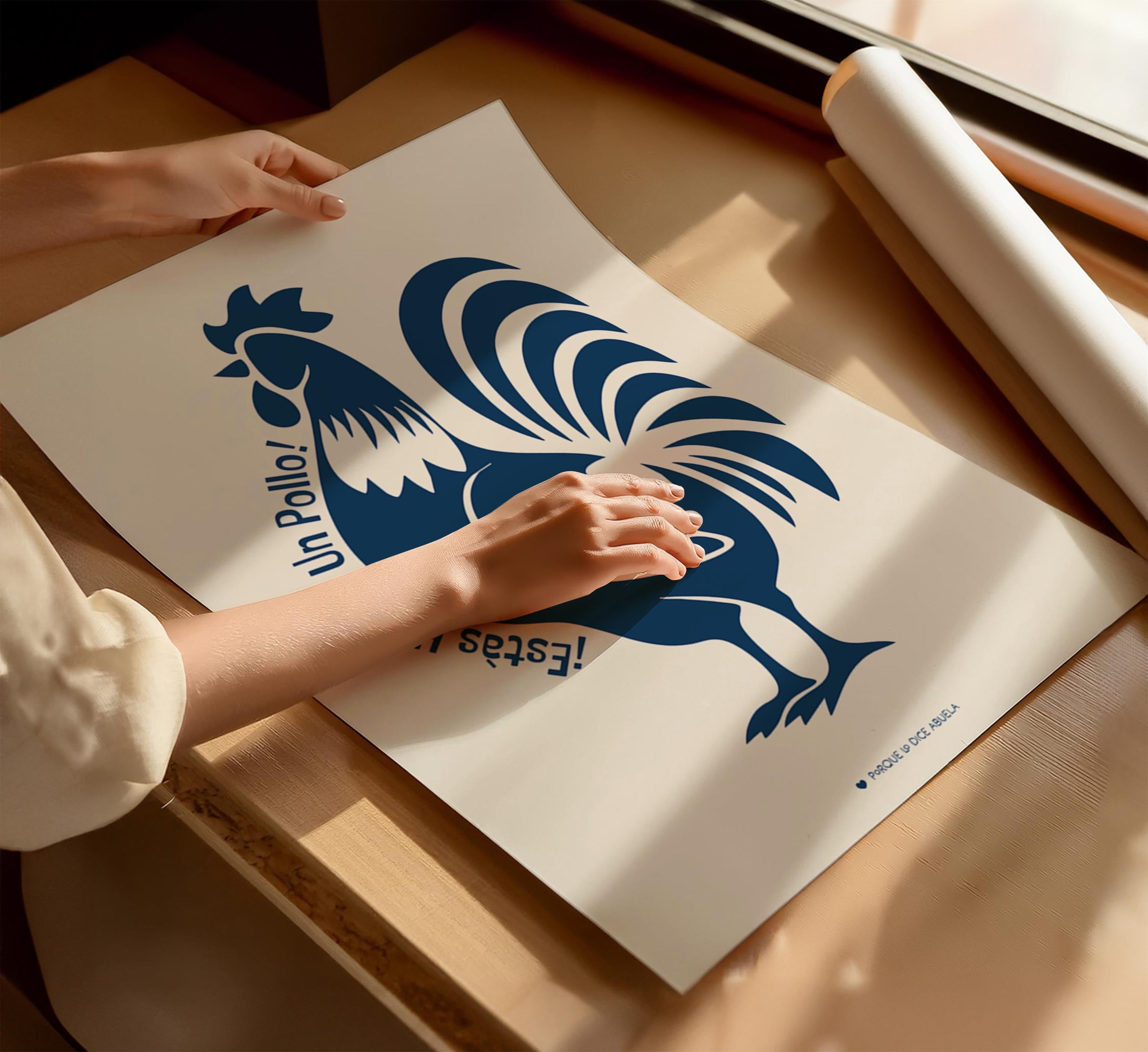 A person's hands are holding a large poster with a rooster design on it, which appears to be a printed material.