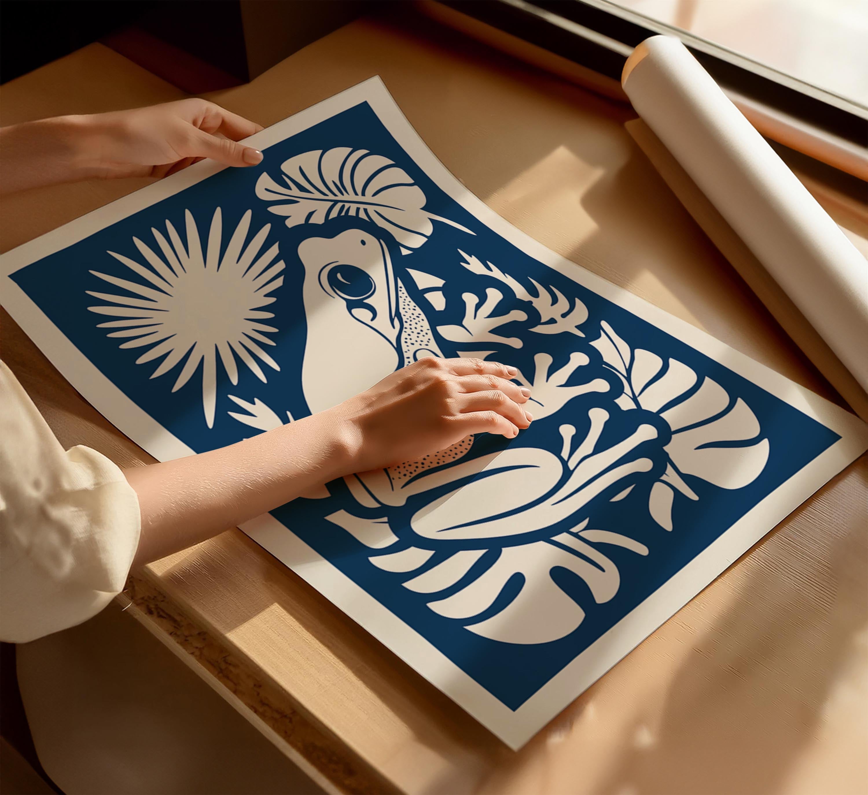 A person's hands are holding a blue and white poster featuring a frog and tropical plants.