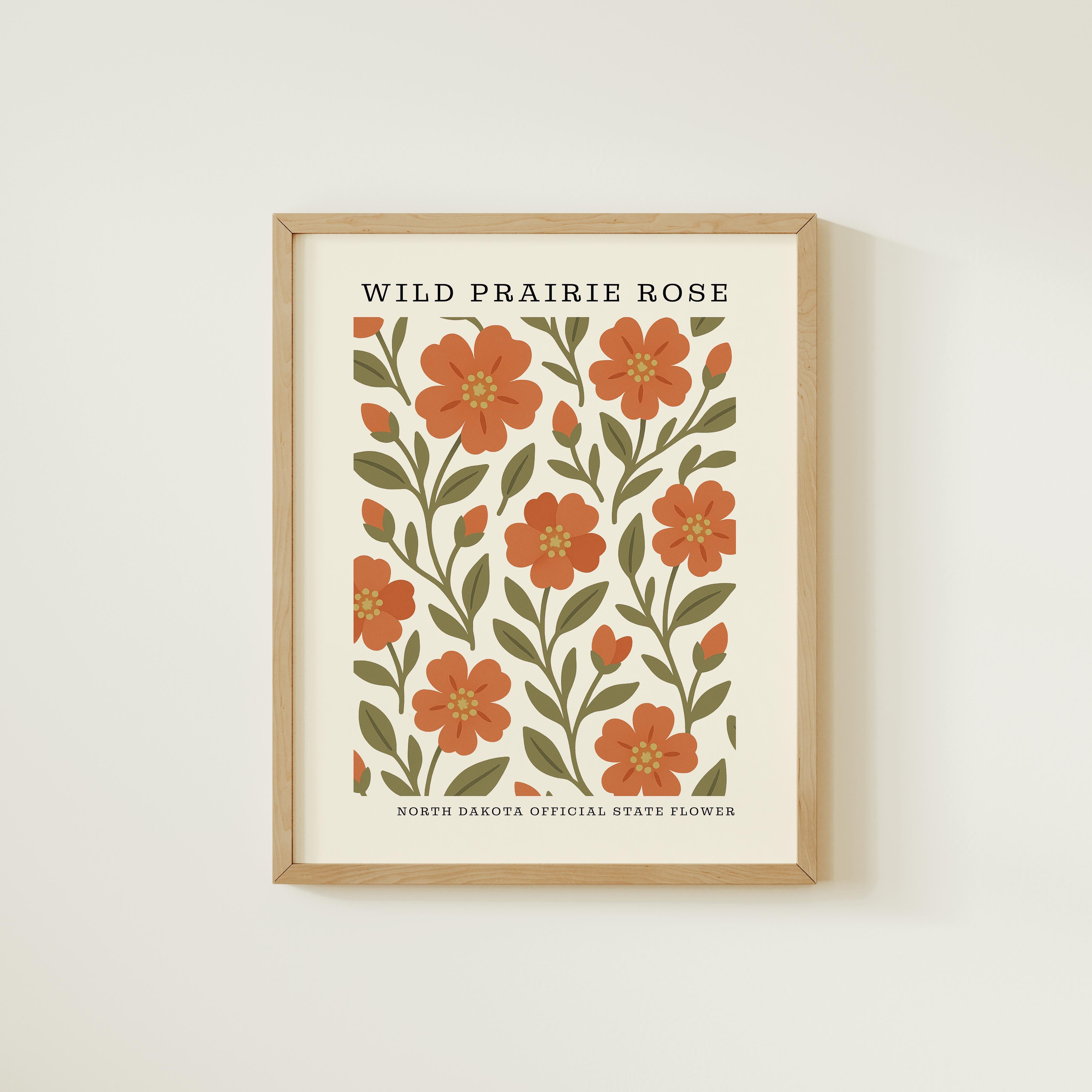 The image is a framed print featuring a repeating pattern of wild prairie roses, with the text "WILD PRIREE ROSE" and "NORTH DAKOTA OFFICIAL STATE FLOWER" printed on it.